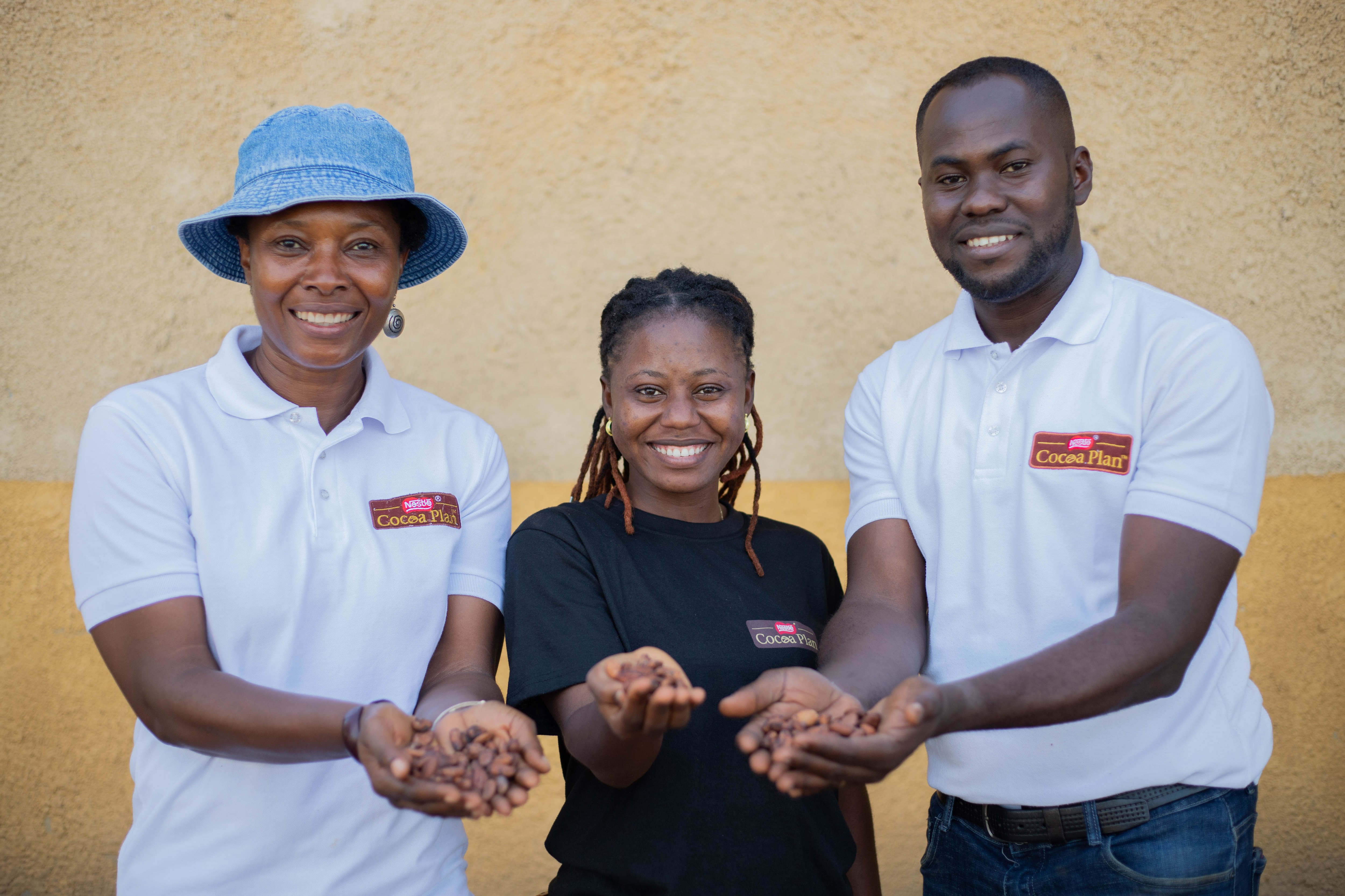 people smiling holding cocoa beans